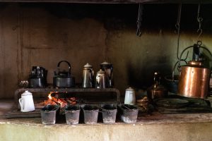 The hearth in the Farm House kitchen where coffee is roasted, ground and prepared on the fire in an enamel kettle, and bread is baked daily.